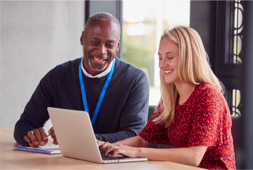 Instructor and student working together on laptop.