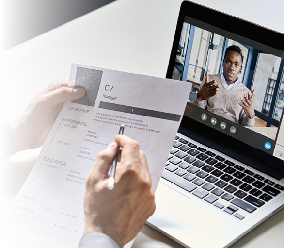 A person reviews a resume titled "CV Manager" while on a video call with a gesturing man on a laptop.