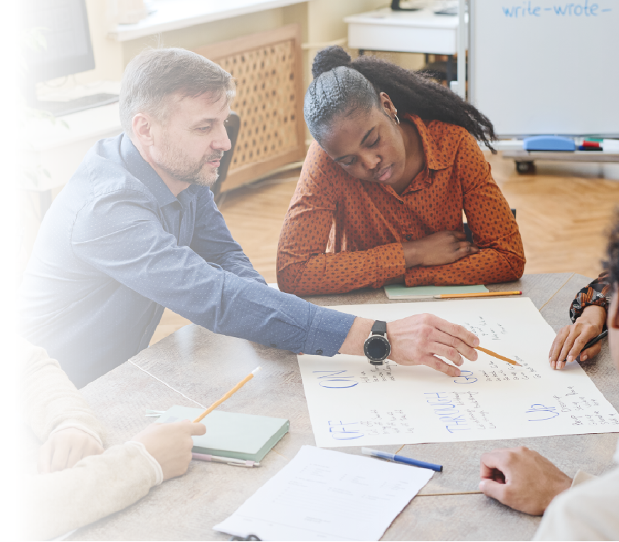 Faculty and administrators collaborating on strategic planning documents and charts for higher education goals.