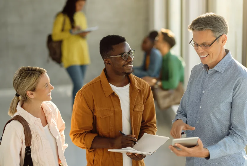 An instructor guiding two students in a collaborative discussion.