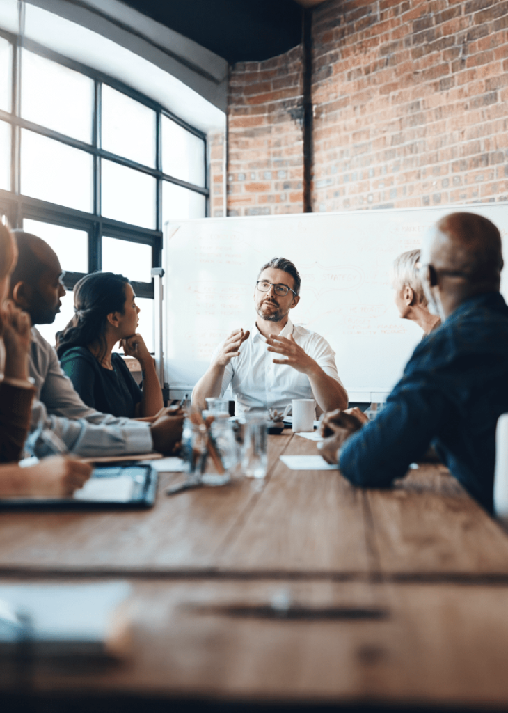 Business team meeting in modern brick-walled conference room having a discussion