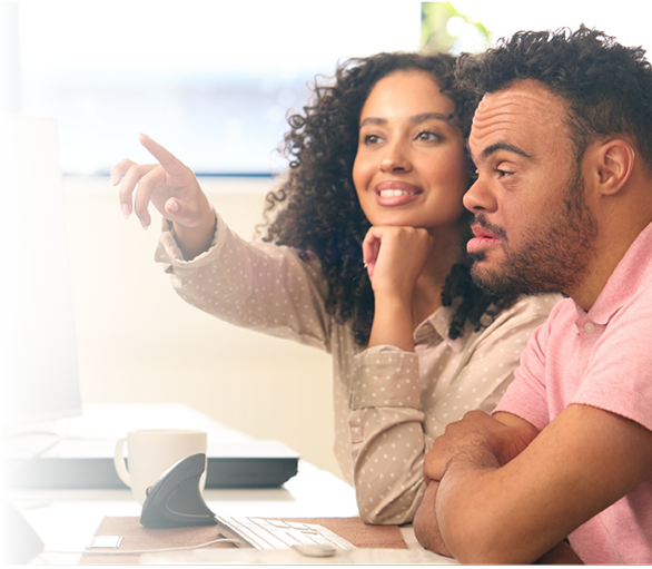 A woman instructor guides a neurodivergent student at a computer, showing inclusive digital learning.