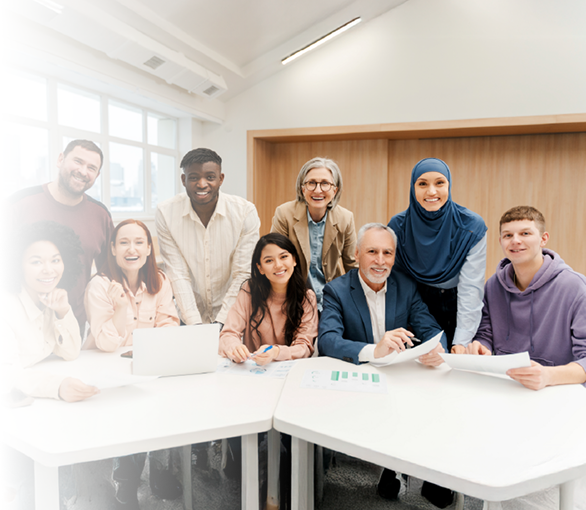Diverse faculty and students collaborating around a conference table in a modern classroom.